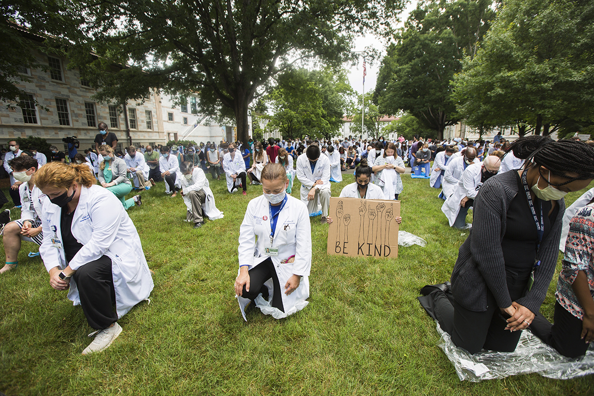 photo of demonstrators kneeling on a lawn