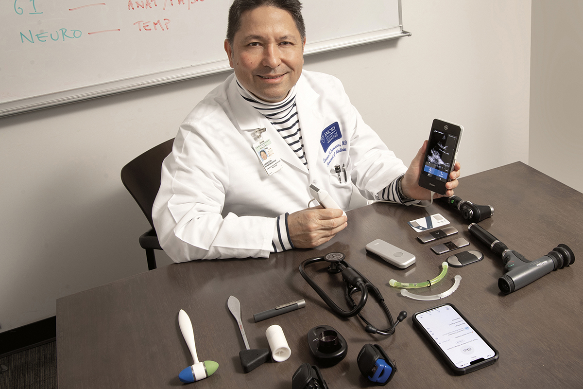 Emory internist Lorenzo Di Francesco sits at a table with technical equipment 