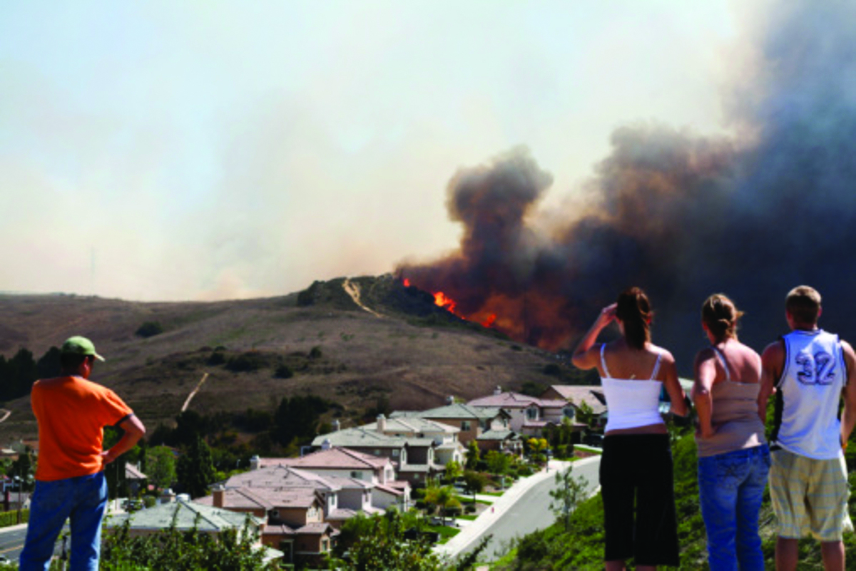 Photo of wildfire with people watching.