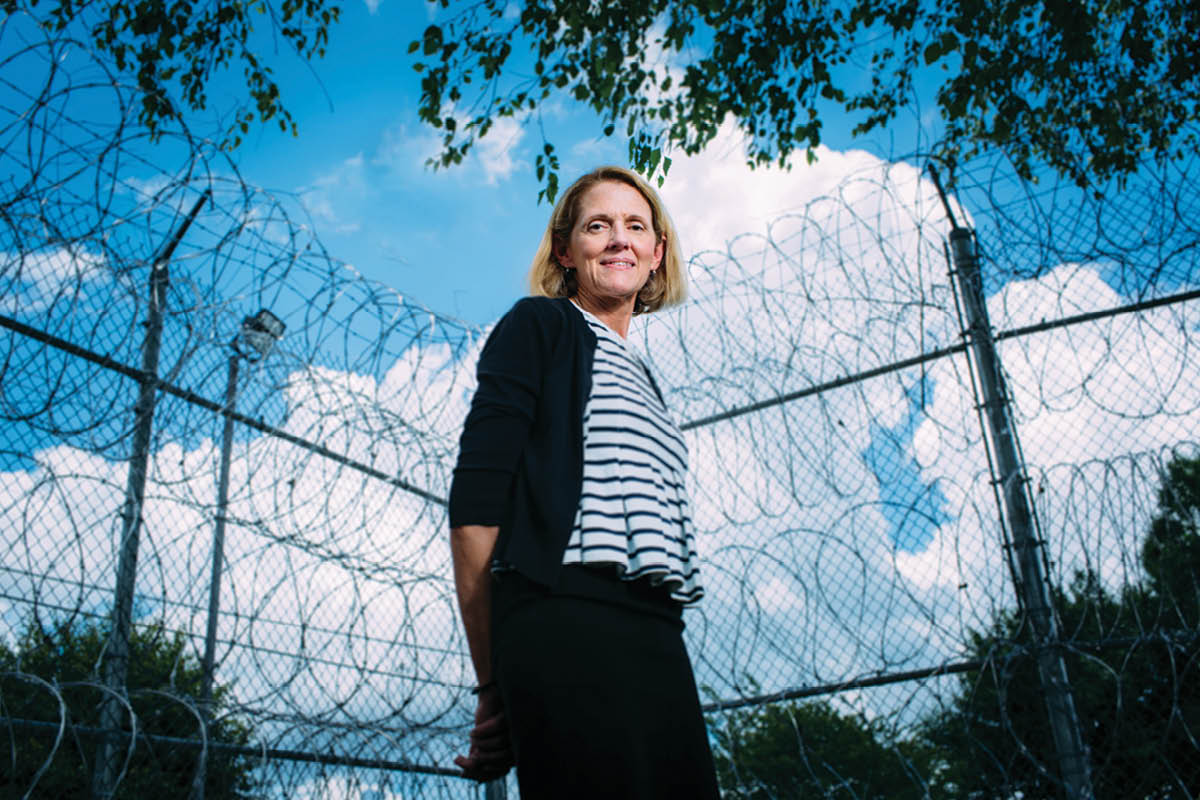 Photo of Anne Spaulding standing outside in front of a chainlink fence